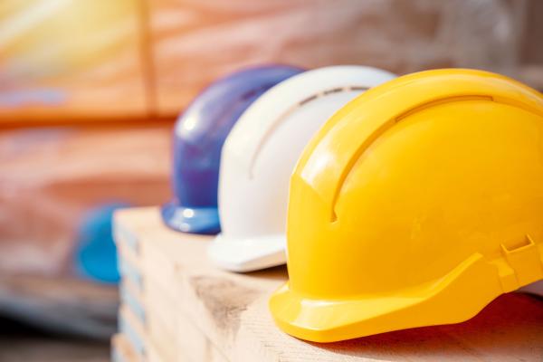 three construction work helmets resting on shelf